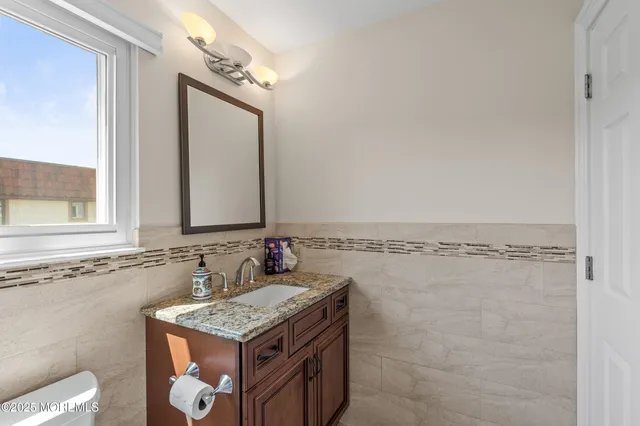 a bathroom with a granite countertop sink a mirror and a shower