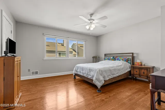 a bedroom with a bed a dresser and a flat screen tv