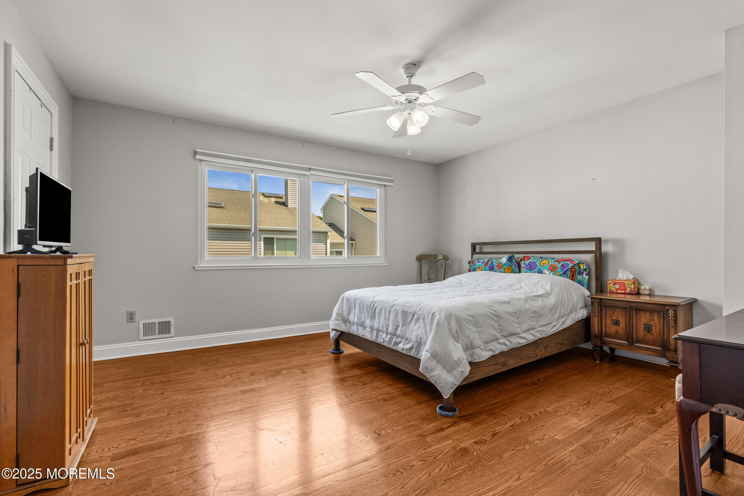 450 Ocean Boulevard, Unit 8 Long Branch, NJ 07740 - Photo 21 of 33 a bedroom with a bed a dresser and a flat screen tv
