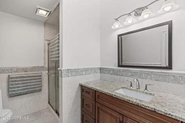a bathroom with a granite countertop sink vanity and mirror