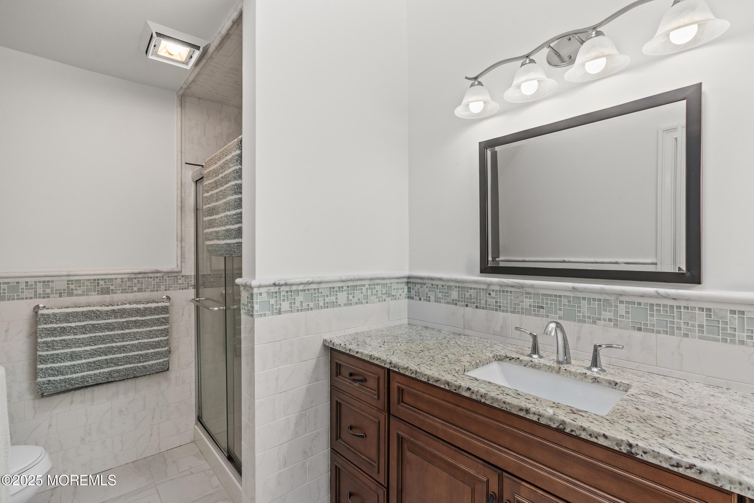 450 Ocean Boulevard, Unit 8 Long Branch, NJ 07740 - Photo 23 of 33 a bathroom with a granite countertop sink vanity and mirror