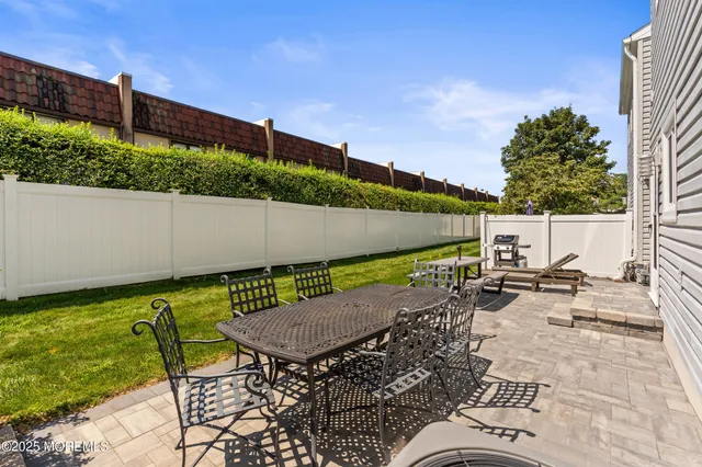 a view of backyard with seating space and trees in the background