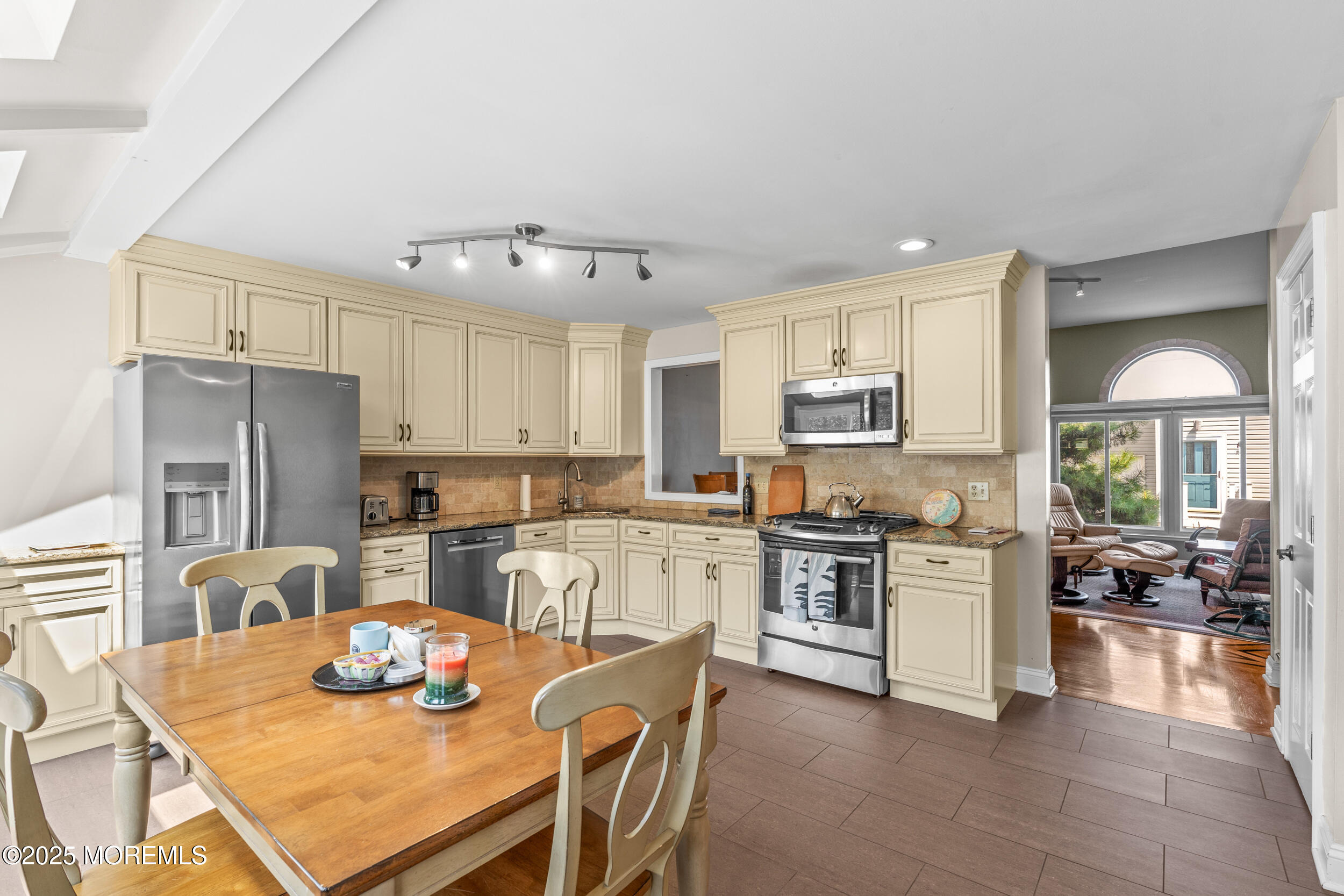 450 Ocean Boulevard, Unit 8 Long Branch, NJ 07740 - Photo 10 of 33 a kitchen with stainless steel appliances granite countertop a stove top oven a dining table and chairs