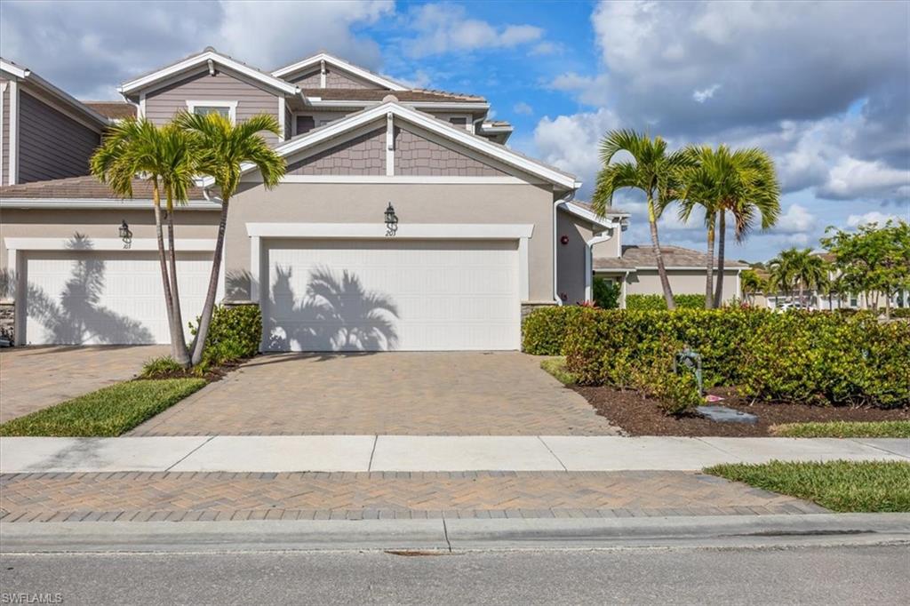 a front view of a house with a yard and a garage