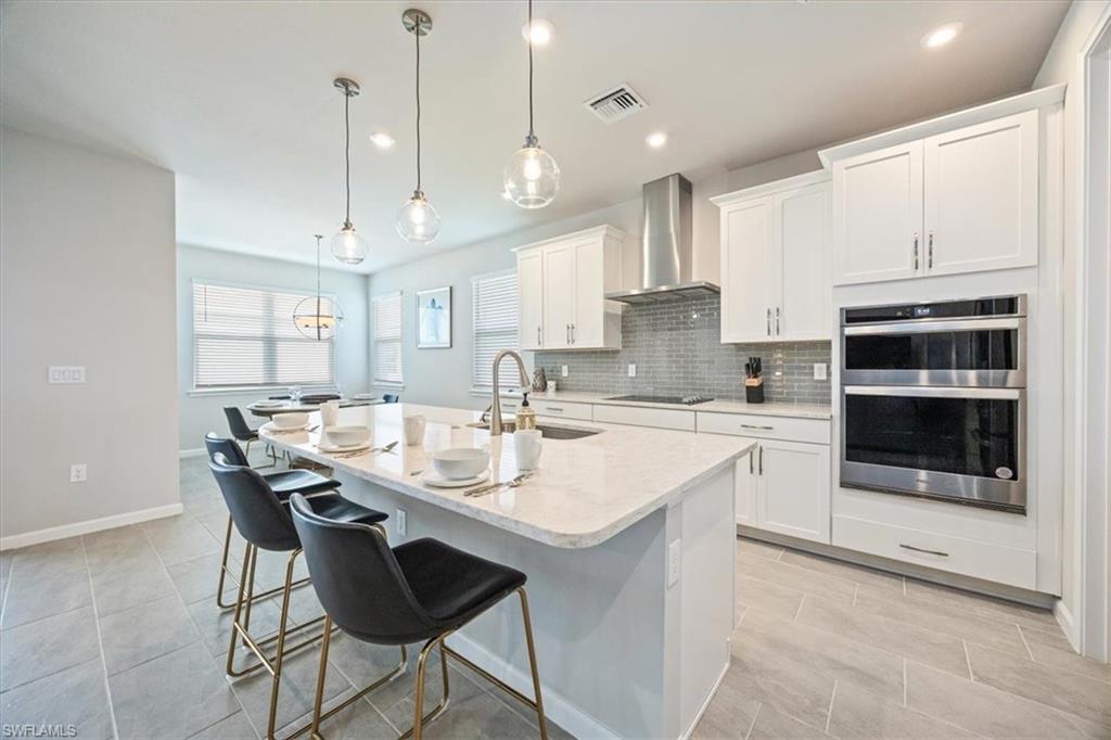4687 Arboretum Circle, Unit 203 Naples, FL 34112 - Photo 11 of 24 a kitchen with stainless steel appliances kitchen island granite countertop a sink and cabinets