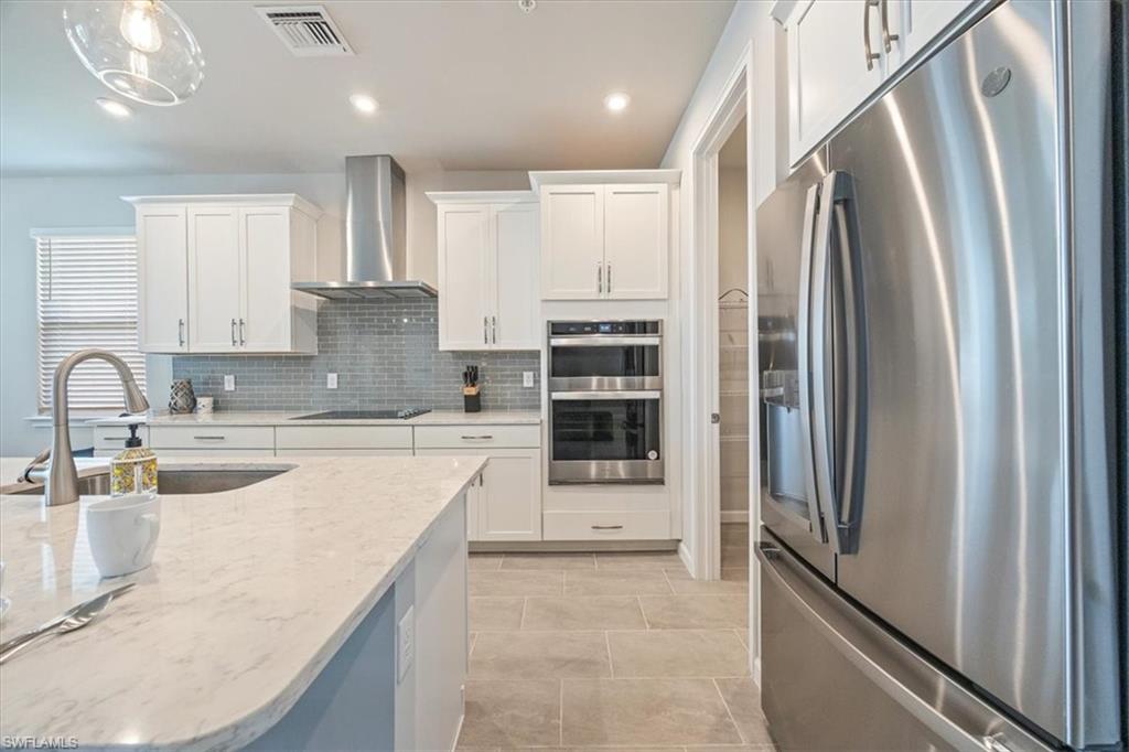 4687 Arboretum Circle, Unit 203 Naples, FL 34112 - Photo 12 of 24 a kitchen with stainless steel appliances granite countertop a refrigerator and a sink
