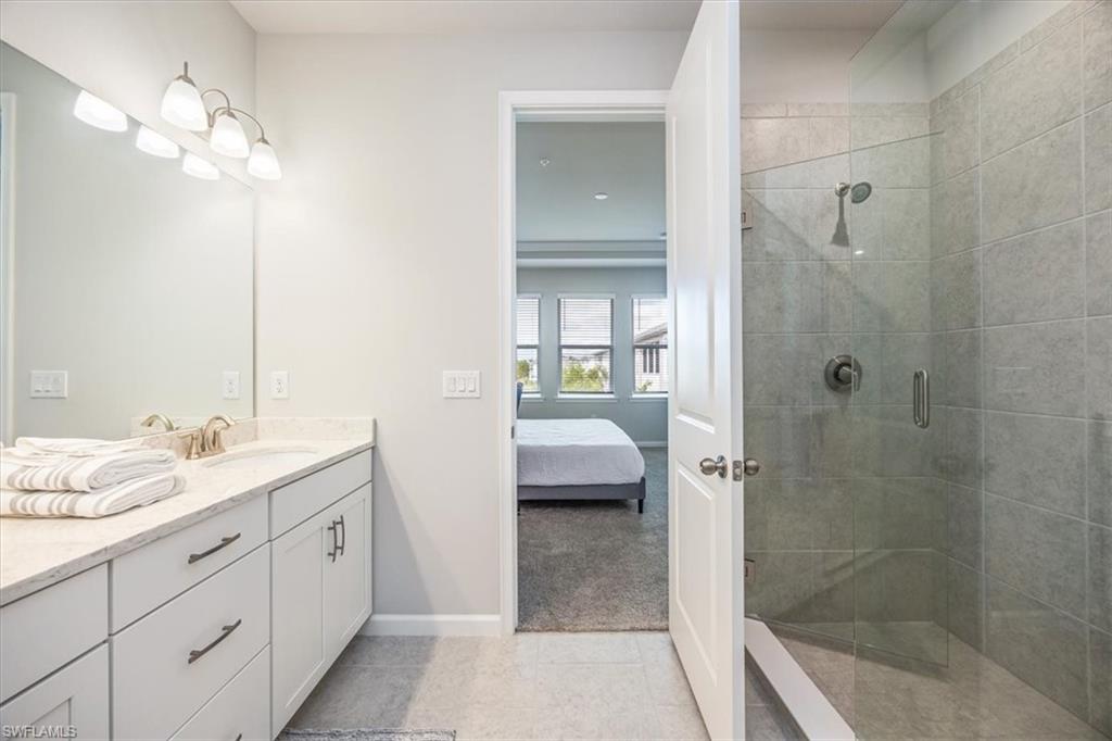 4687 Arboretum Circle, Unit 203 Naples, FL 34112 - Photo 19 of 24 a en suite bathroom with a granite countertop sink a toilet and shower