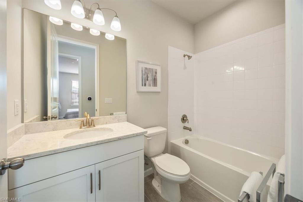 4687 Arboretum Circle, Unit 203 Naples, FL 34112 - Photo 23 of 24 a bathroom with a sink a toilet and a mirror