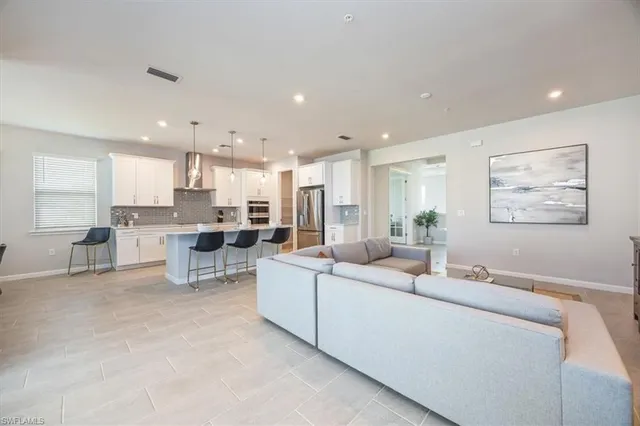 a living room with furniture and kitchen view