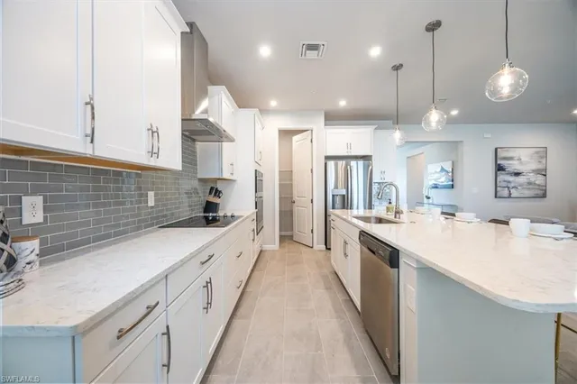 a large kitchen with kitchen island a sink a counter space and stainless steel appliances