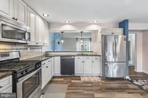 a kitchen with stainless steel appliances granite countertop a refrigerator stove and sink