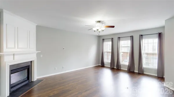 a view of an empty room with a window and fireplace