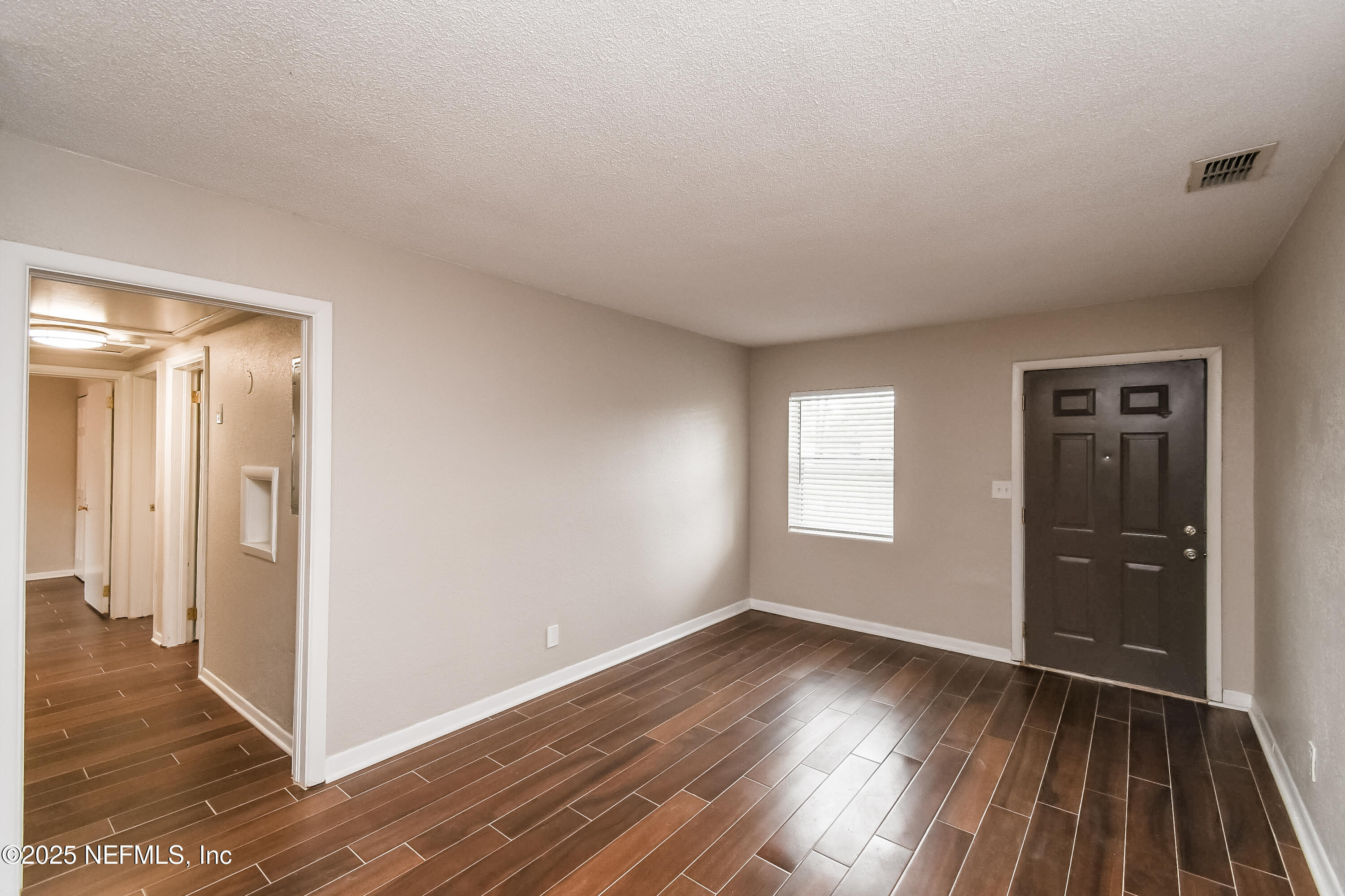 10429 Anders Boulevard Jacksonville, FL 32246 - Photo 2 of 15 an empty room with wooden floor and windows