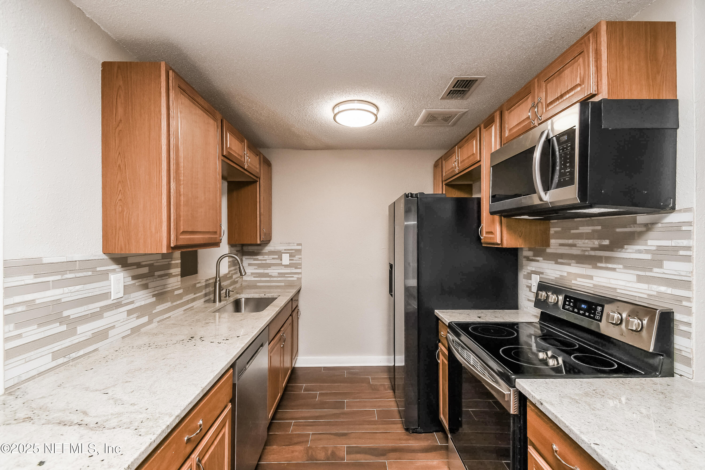 10429 Anders Boulevard Jacksonville, FL 32246 - Photo 4 of 15 a kitchen with stainless steel appliances granite countertop a stove a sink and a microwave