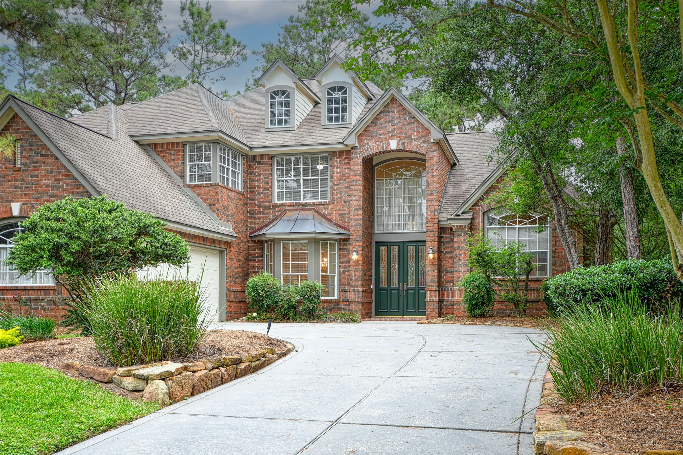 2 Woodmere Place Spring, TX 77381 - Photo 2 of 20 a front view of a house with garden