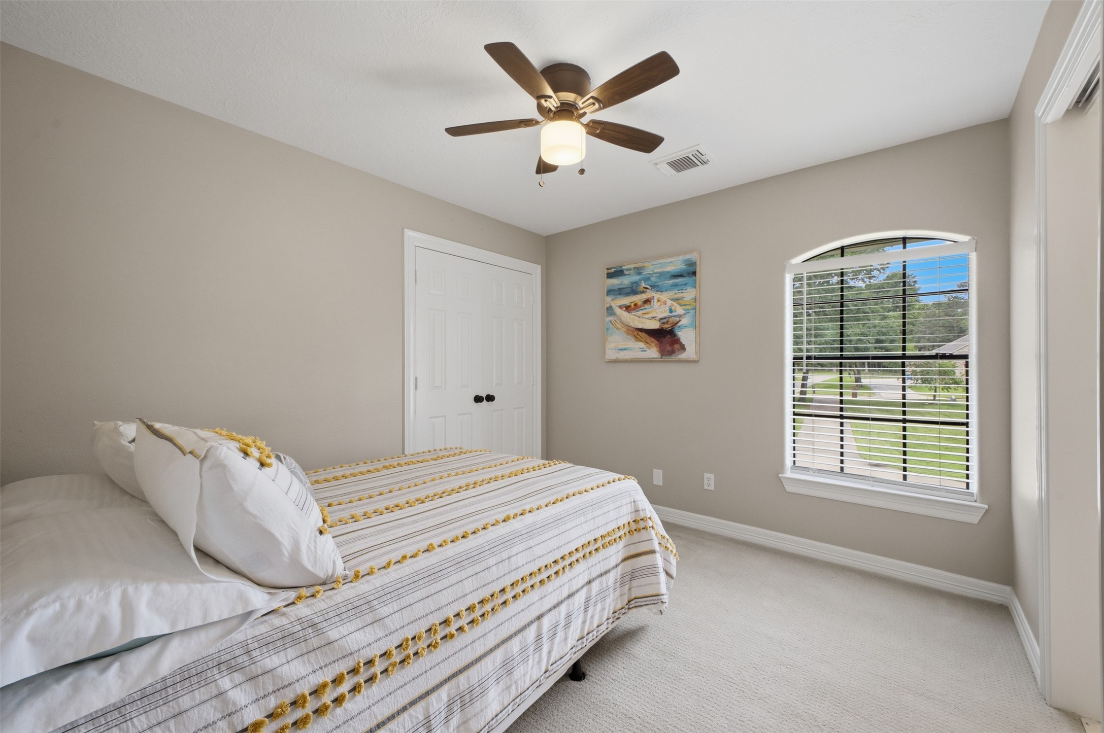 12710 Aries Loop Willis, TX 77318 - Photo 28 of 40 Bedroom featuring light gray walls, a ceiling fan with light, and a large arched window with blinds providing a view of the outdoors