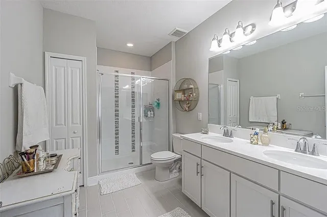 a spacious bathroom with a double vanity sink mirror and toilet