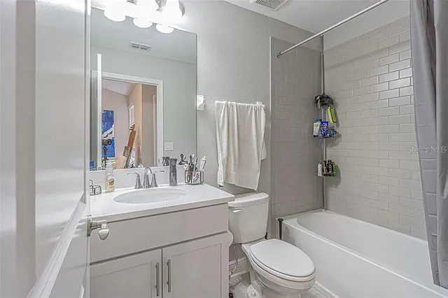 a bathroom with a sink a toilet a mirror and shower