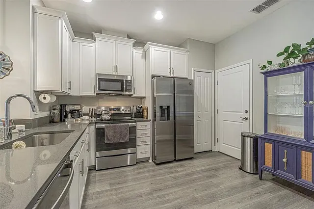 a kitchen with stainless steel appliances a refrigerator sink and stove