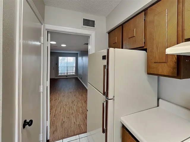 a view of kitchen with furniture and refrigerator