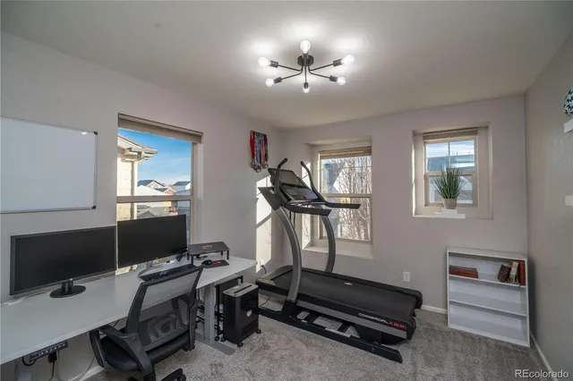 a view of a workspace with furniture and a window