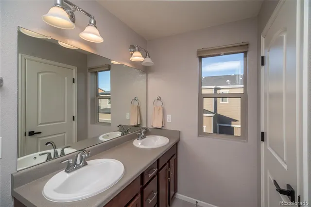 a bathroom with double vanity sinks and a mirror