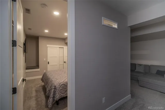a view of a hallway with closet and a bathroom