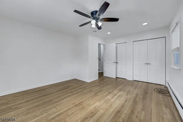 a view of an empty room with wooden floor