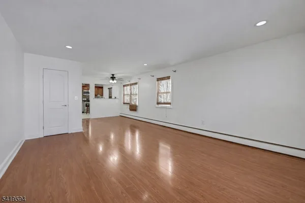 a view of empty room with wooden floor