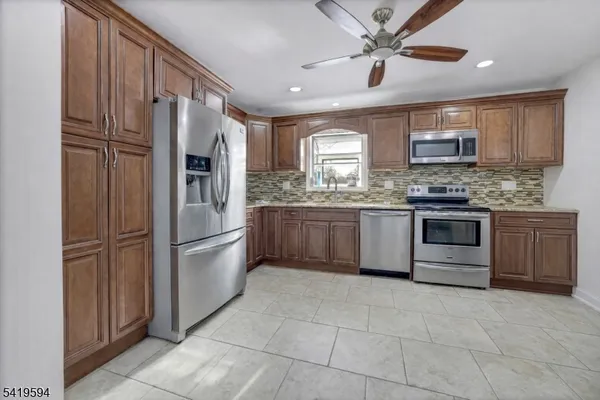 a kitchen with stainless steel appliances granite countertop a stove a refrigerator and a sink