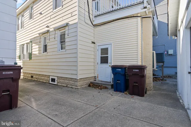 a view of a house with a barbeque and wooden fence