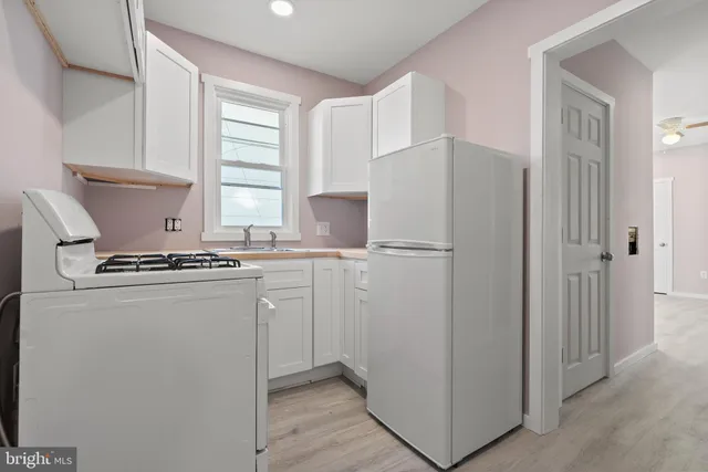 a kitchen with refrigerator a stove a sink and a window