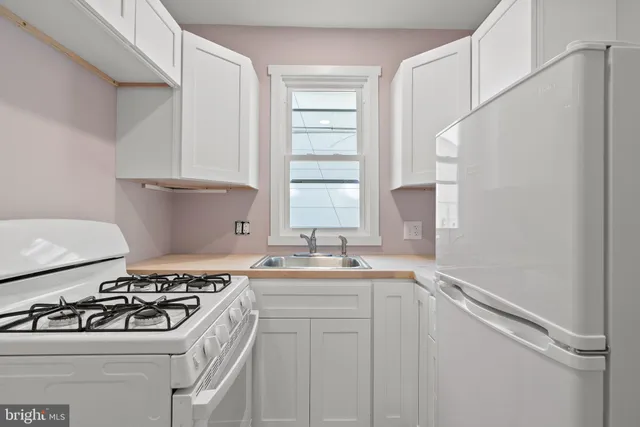 a kitchen with a sink stove top oven and cabinets