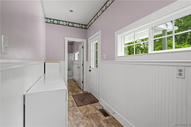 a view of a hallway with wooden floor and staircase