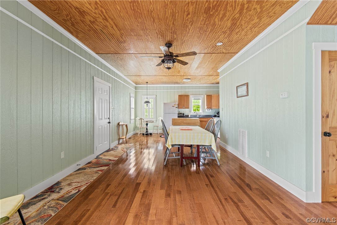 858 Chapel Road New Canton, VA 23123 - Photo 33 of 48 a dining room with wooden floor a chandelier a wooden table and chairs