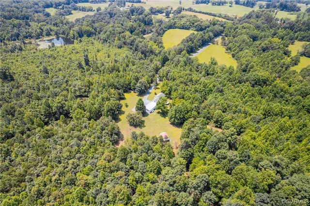 an aerial view of a house with a yard and lake view