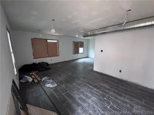 a view of empty room with wooden floor