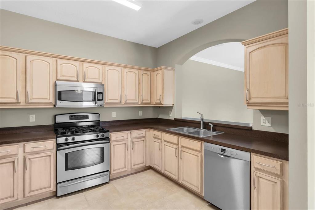 10121 Porch Street New Port Richey, FL 34655 - Photo 10 of 57 a kitchen with granite countertop white cabinets white stainless steel appliances and sink