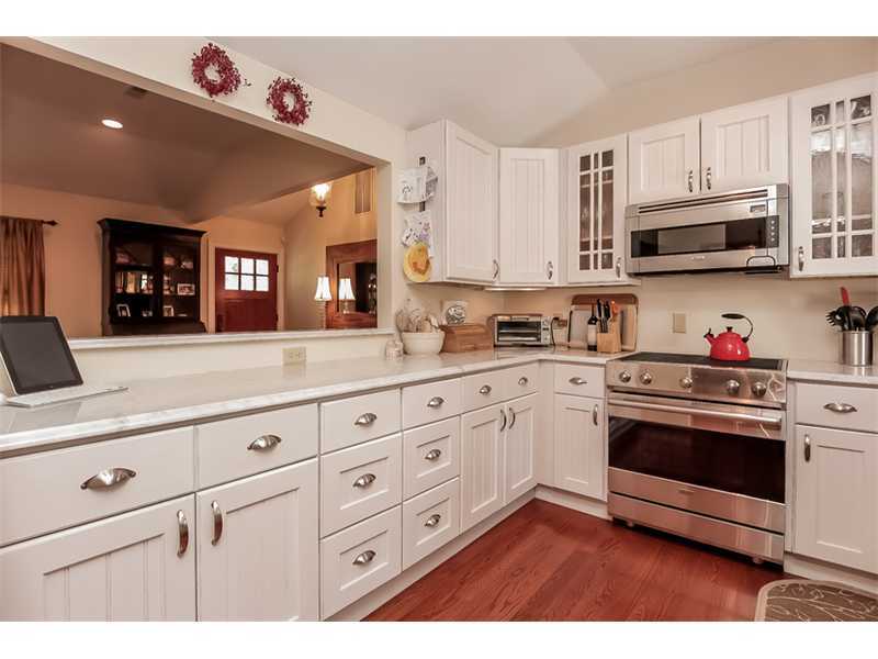5 Archer Lane Darien, CT 06820 - Photo 6 of 17 a kitchen with granite countertop white cabinets stainless steel appliances and wooden floor