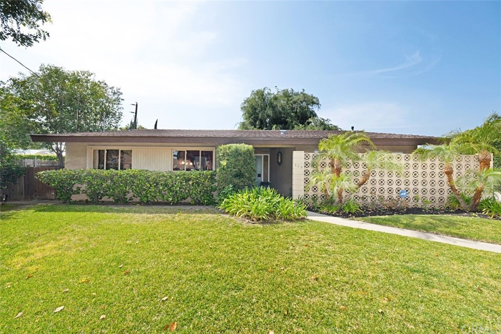 a front view of a house with a yard and potted plants