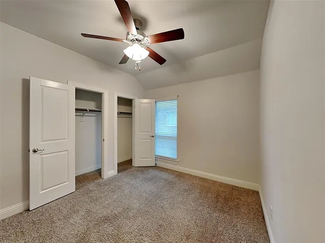 an empty room with closet and windows