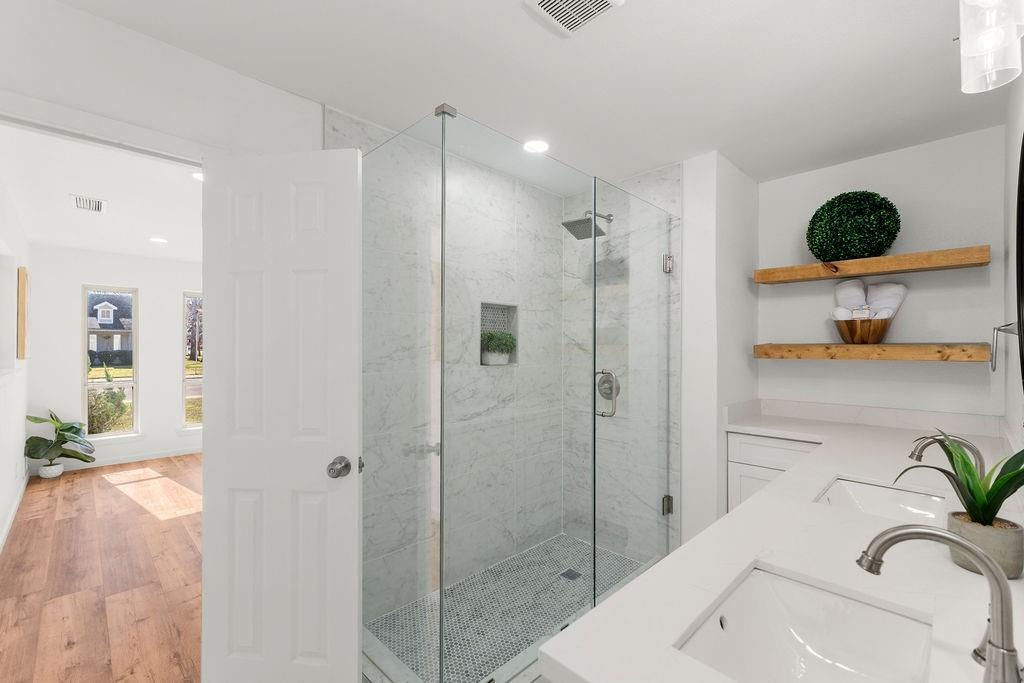 11022 Ferndale Road Dallas, TX 75238 - Photo 17 of 37 a bathroom with a granite countertop sink a mirror a bathtub and shower