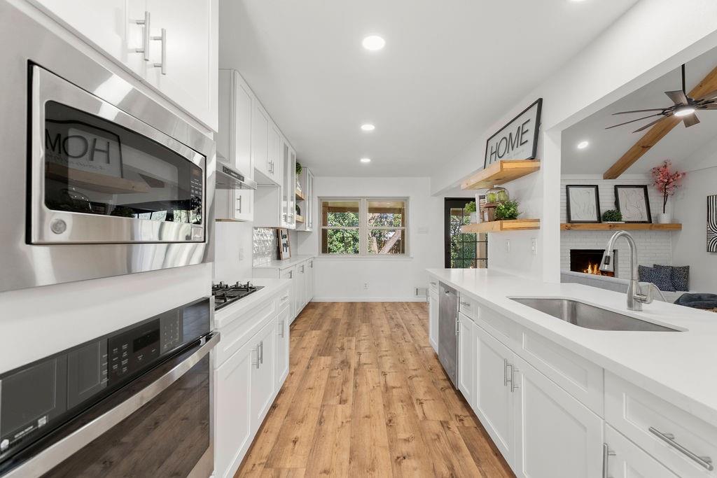 11022 Ferndale Road Dallas, TX 75238 - Photo 9 of 37 a large kitchen with stainless steel appliances granite countertop a lot of counter space and wooden floor