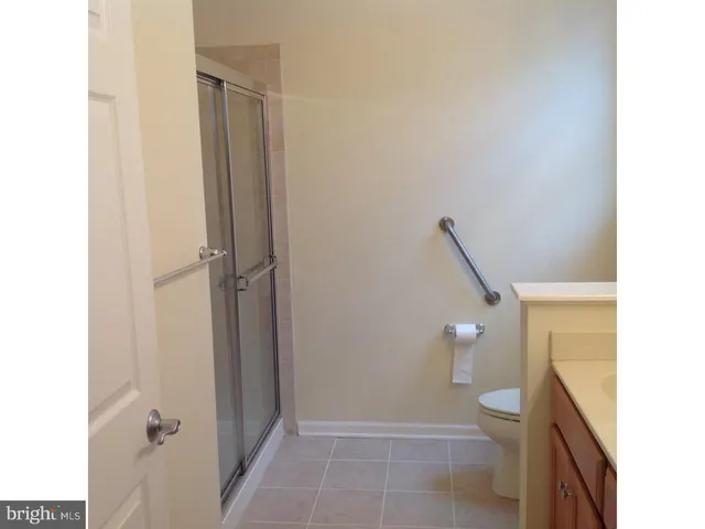 a bathroom with a granite countertop shower and a toilet