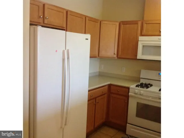 a kitchen with a refrigerator sink and cabinets
