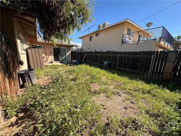 a view of a house with wooden fence and a small yard
