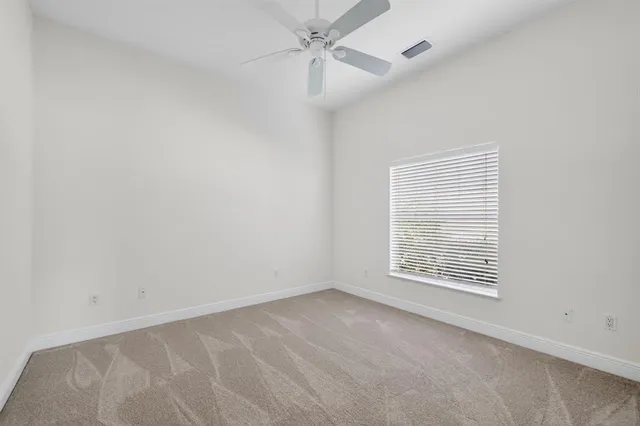 an empty room with fan and windows