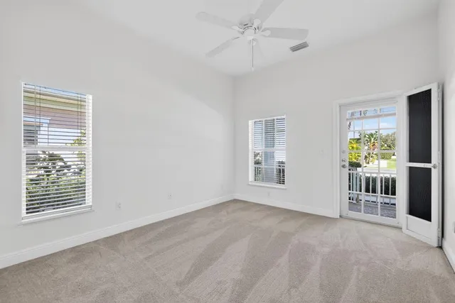 an empty room with fan and entrance