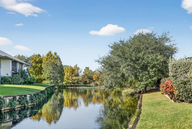 a view of a patio with couches table and chairs under an umbrella