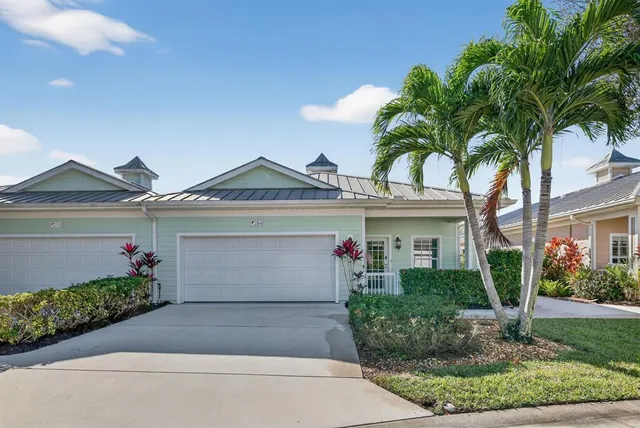 a view of a house with entryway and flower plants